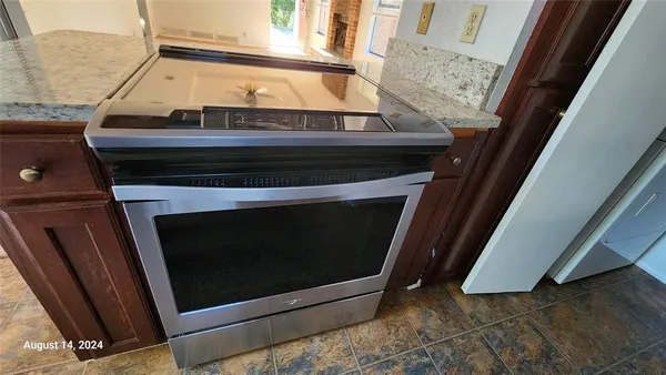a kitchen with granite countertop white cabinets and stainless steel appliances