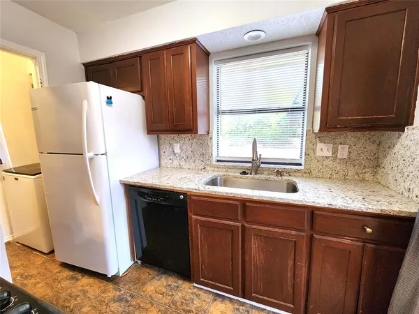 a view of a storage and utility room with refrigerator