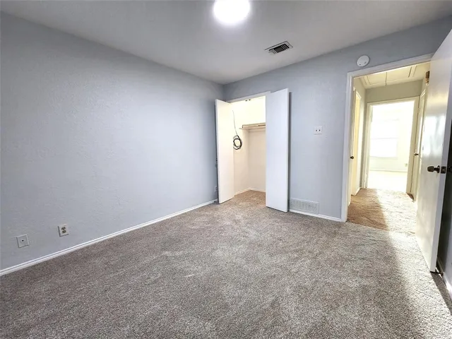 an empty room with windows and closet
