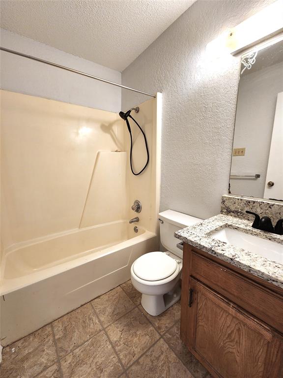 2202 Bolivar Street Denton, TX 76201 - Photo 31 of 36 a bathroom with a granite countertop sink toilet a mirror and a bathtub