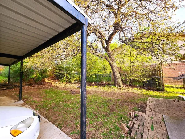 a view of a backyard with a table and chairs under an umbrella