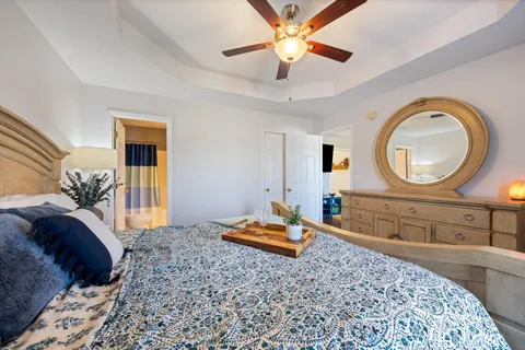 a bedroom with a large bed and a chandelier
