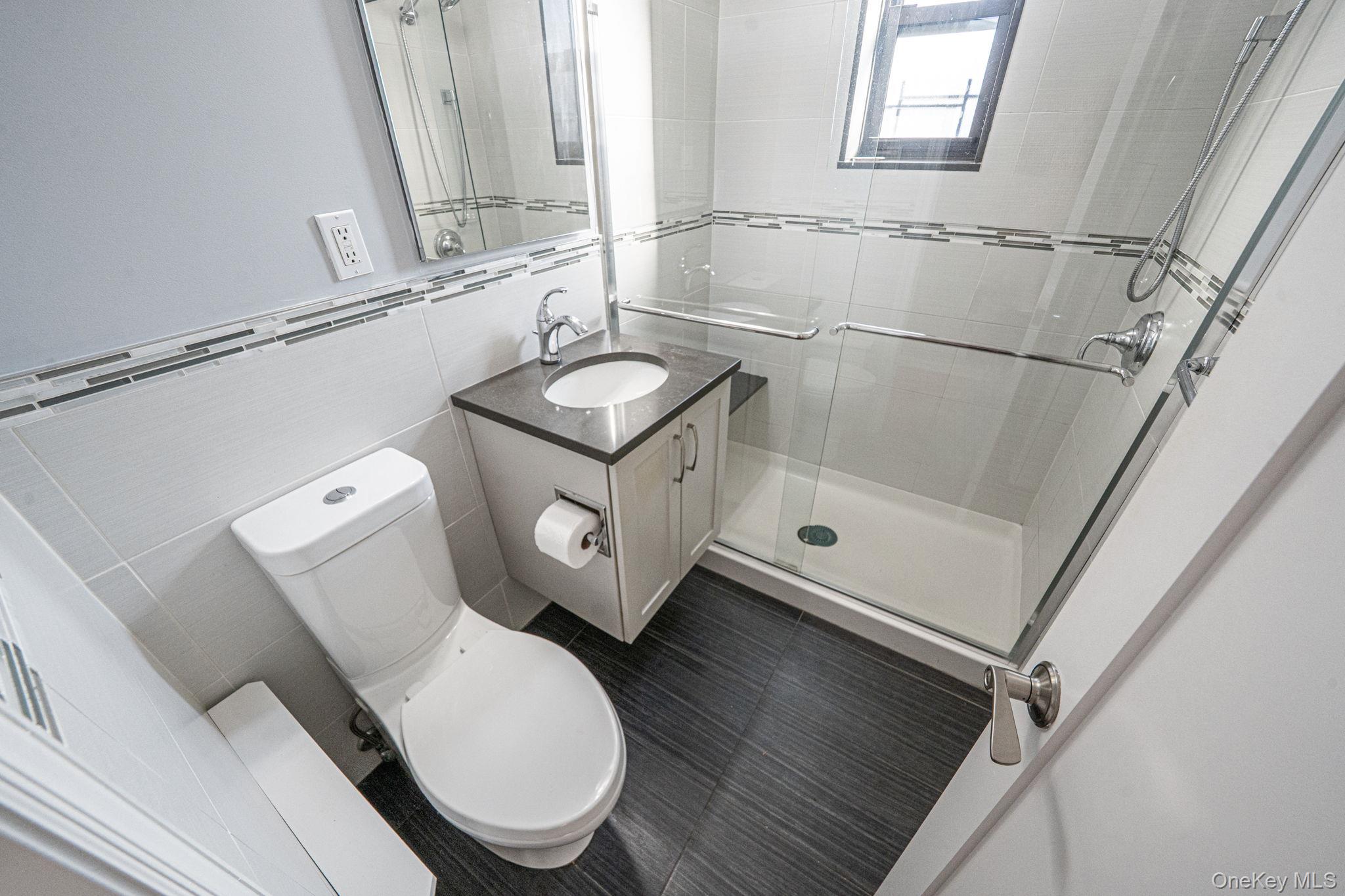 213-05 75th Avenue, Unit 4N Queens, NY 11364 - Photo 14 of 19 Full bath with vanity, a stall shower, and tile walls