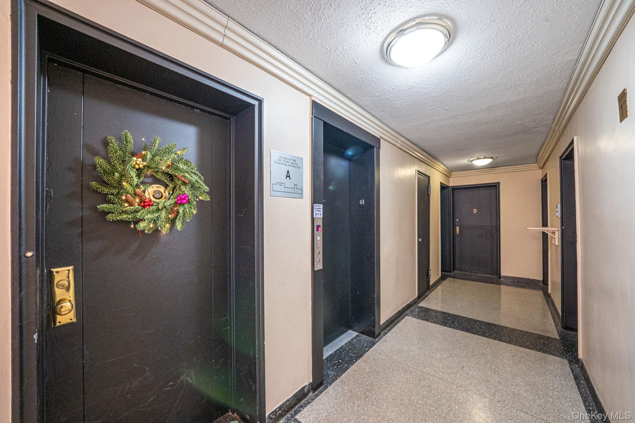213-05 75th Avenue, Unit 4N Queens, NY 11364 - Photo 2 of 19 Corridor featuring a textured ceiling, elevator, and ornamental molding