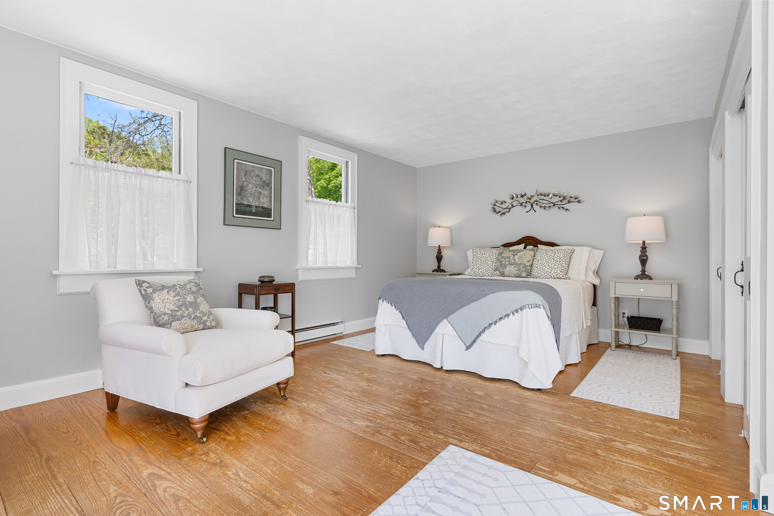93 Upton Road Ashford, CT 06278 - Photo 22 of 40 Spacious main level primary bedroom w/hardwood floors, double closets, and lovely sitting area. First floor Bedroom #3 (3rd of 5 bedrooms in main house).