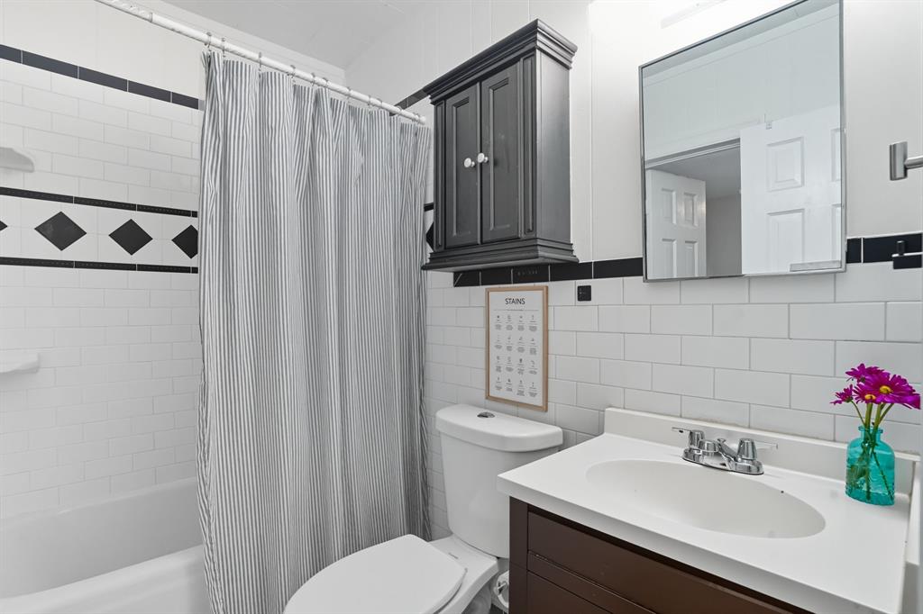 3244 Ryan Avenue Fort Worth, TX 76110 - Photo 23 of 31 a bathroom with a sink a toilet and shower curtain