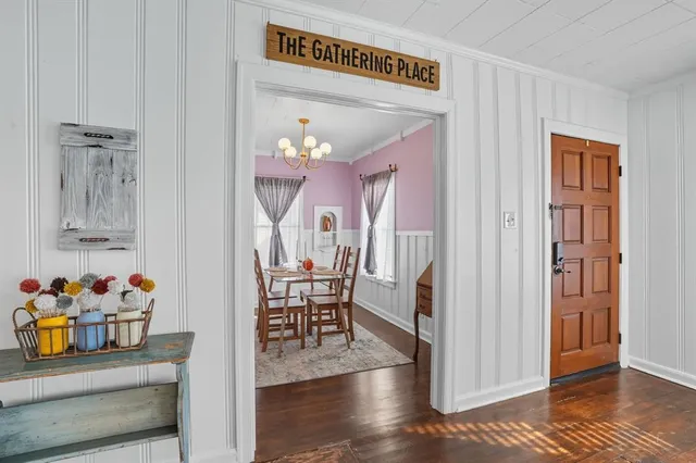 a view of a dining room with wooden floor and a chandelier