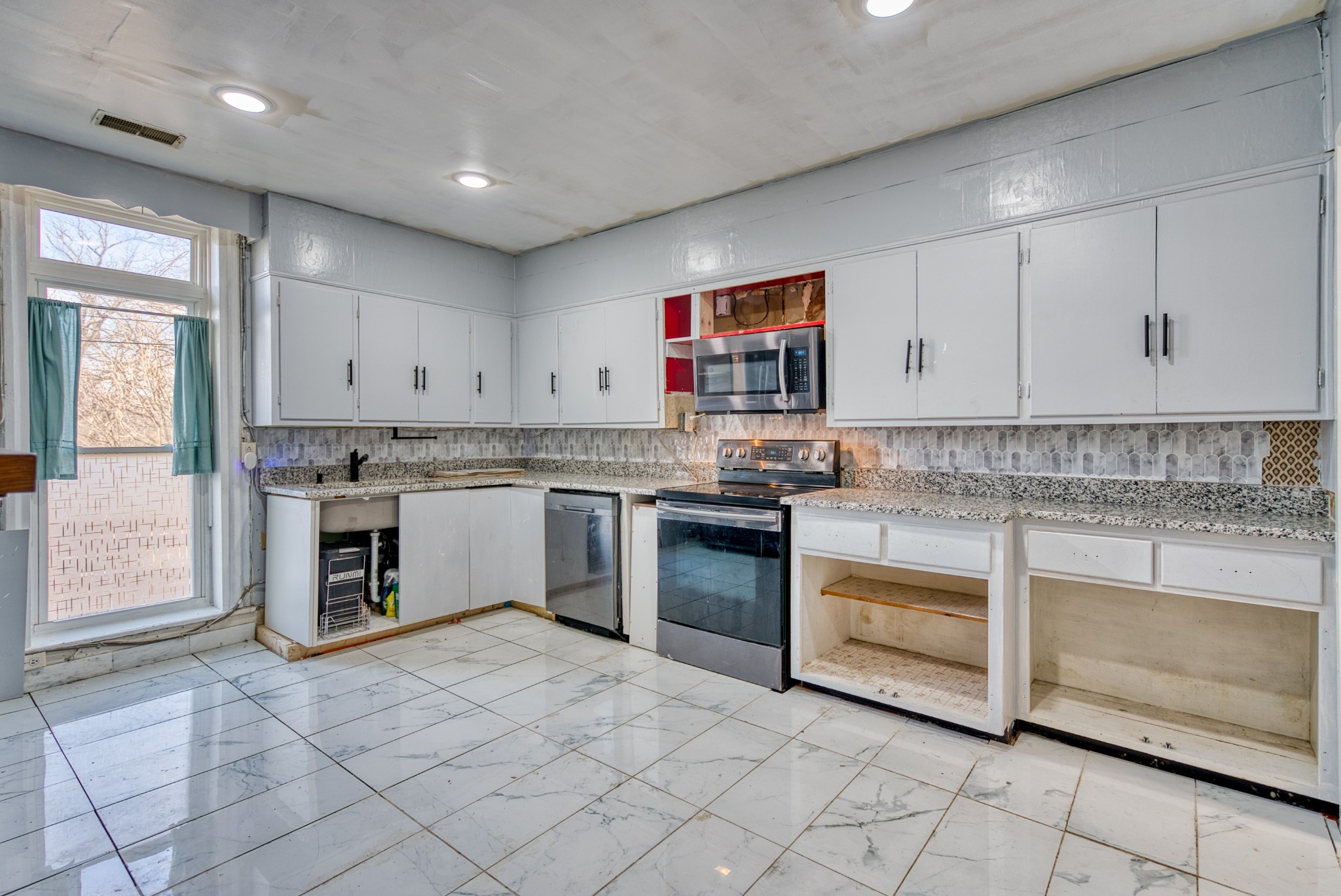 62 North Main Street Springfield, TN 37172 - Photo 16 of 69 a kitchen with stainless steel appliances granite countertop a stove sink and cabinets