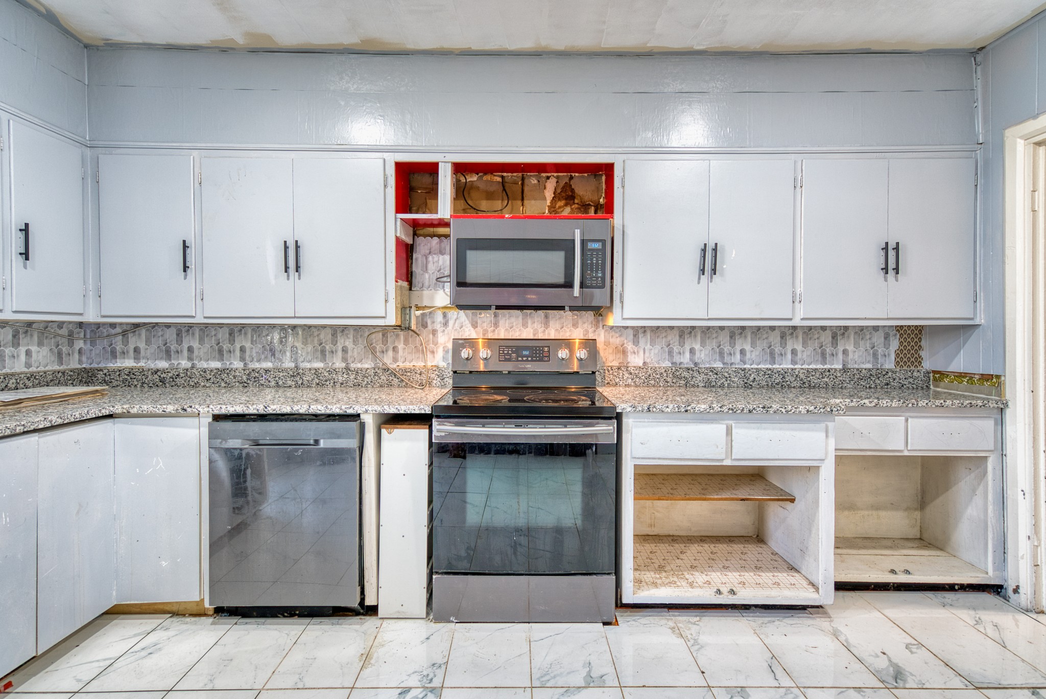 62 North Main Street Springfield, TN 37172 - Photo 18 of 69 a kitchen with granite countertop a stove top oven microwave and cabinets