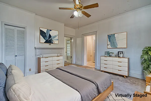 a bedroom with a large bed a flat screen tv and a chandelier