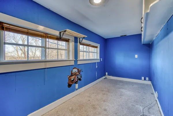 a view of a hallway with wooden floor and a bathroom