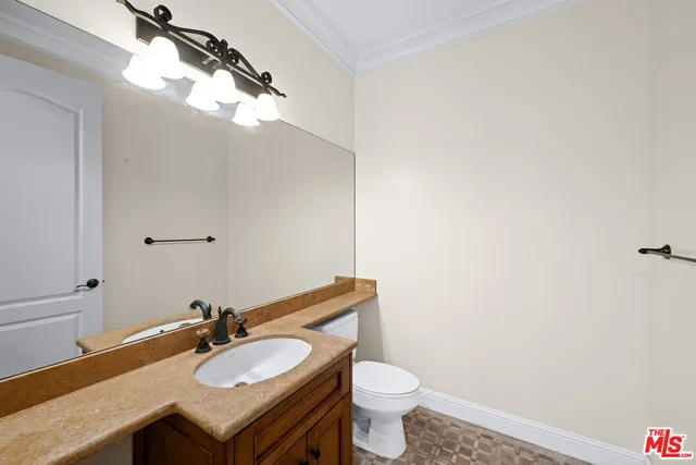 a bathroom with a granite countertop sink vanity mirror and toilet