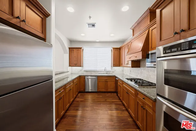 a kitchen with stainless steel appliances granite countertop a stove and a sink