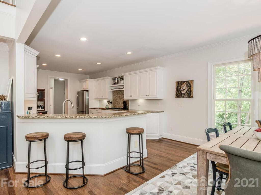 3025 Sharon Road Charlotte, NC 28211 - Photo 11 of 32 a kitchen with granite countertop white cabinets and chairs