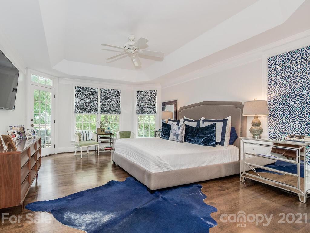 3025 Sharon Road Charlotte, NC 28211 - Photo 15 of 32 a bedroom with a large bed a chandelier and a window
