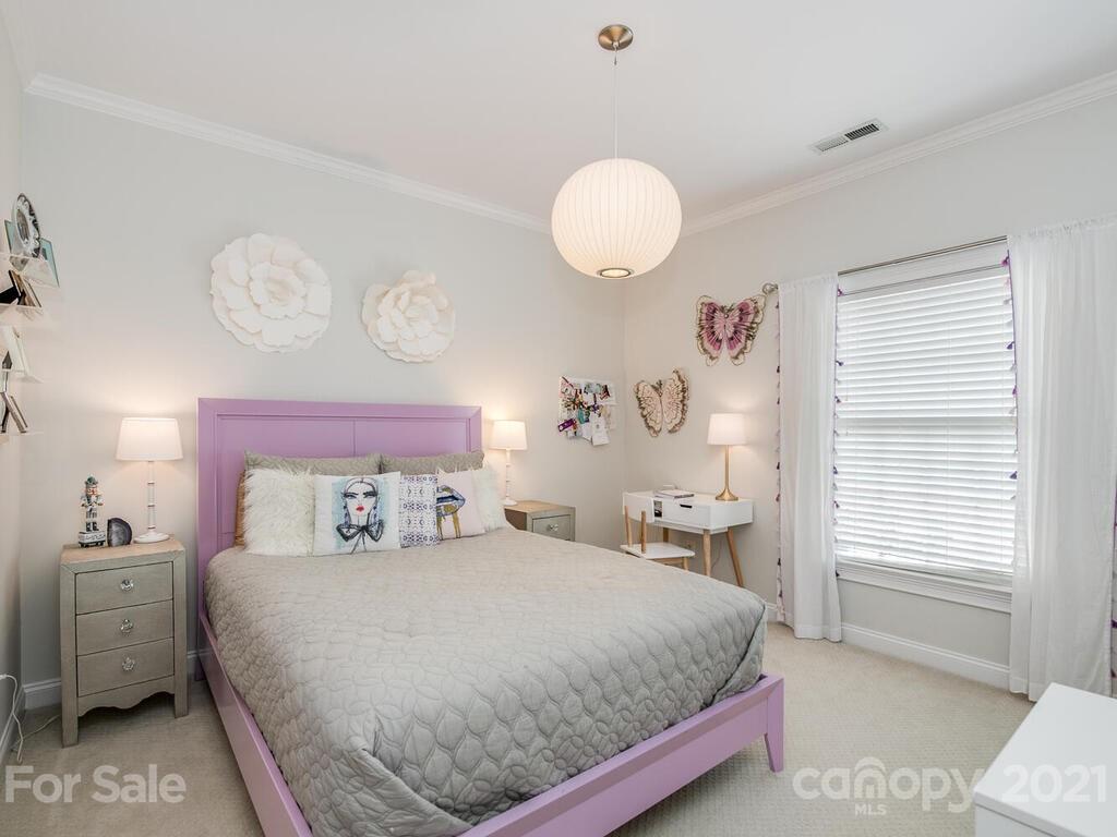 3025 Sharon Road Charlotte, NC 28211 - Photo 24 of 32 a bedroom with a bed and a chandelier