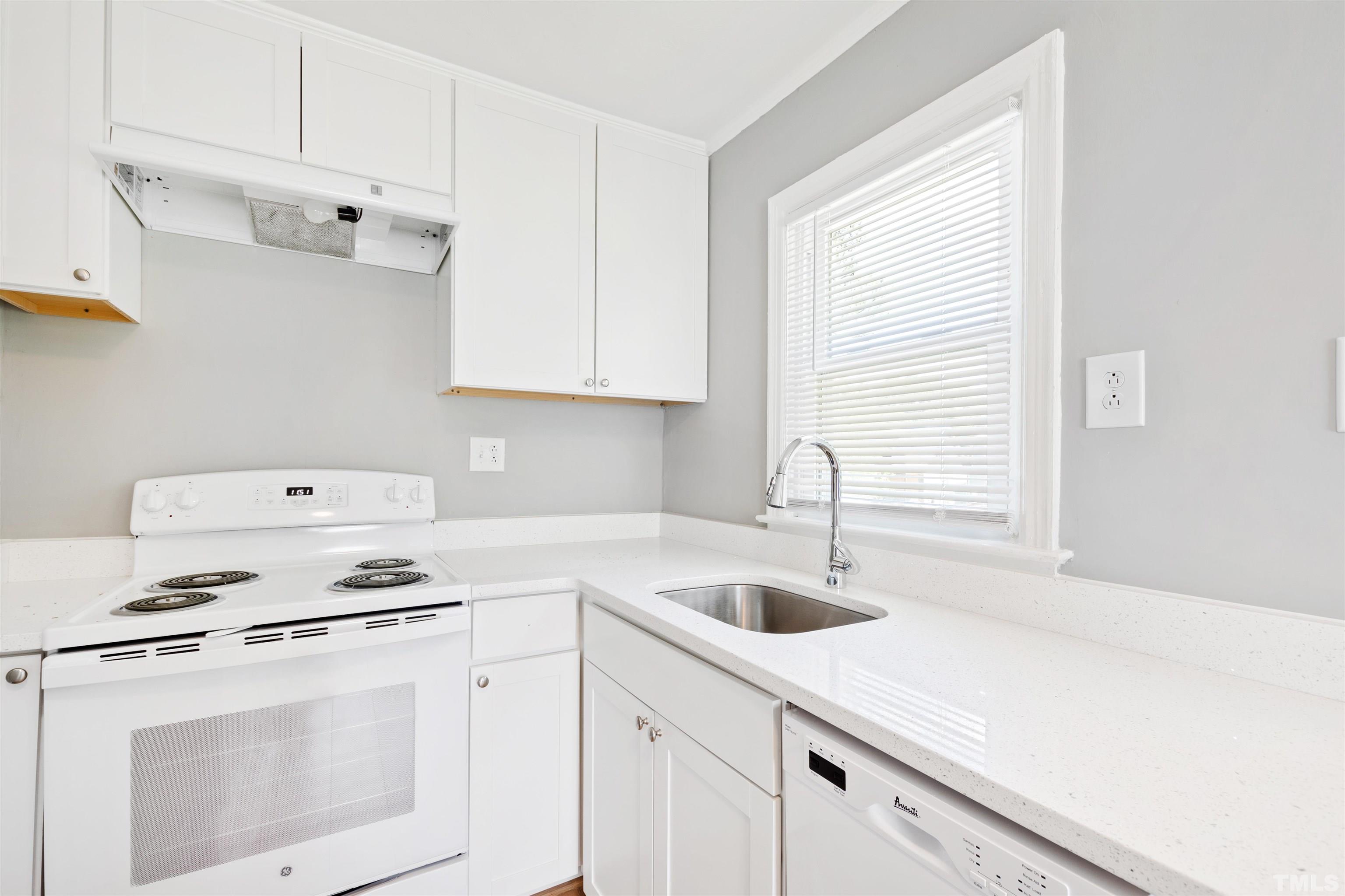 207 Baggett Avenue Raleigh, NC 27604 - Photo 15 of 27 a kitchen with cabinets appliances a sink and a window