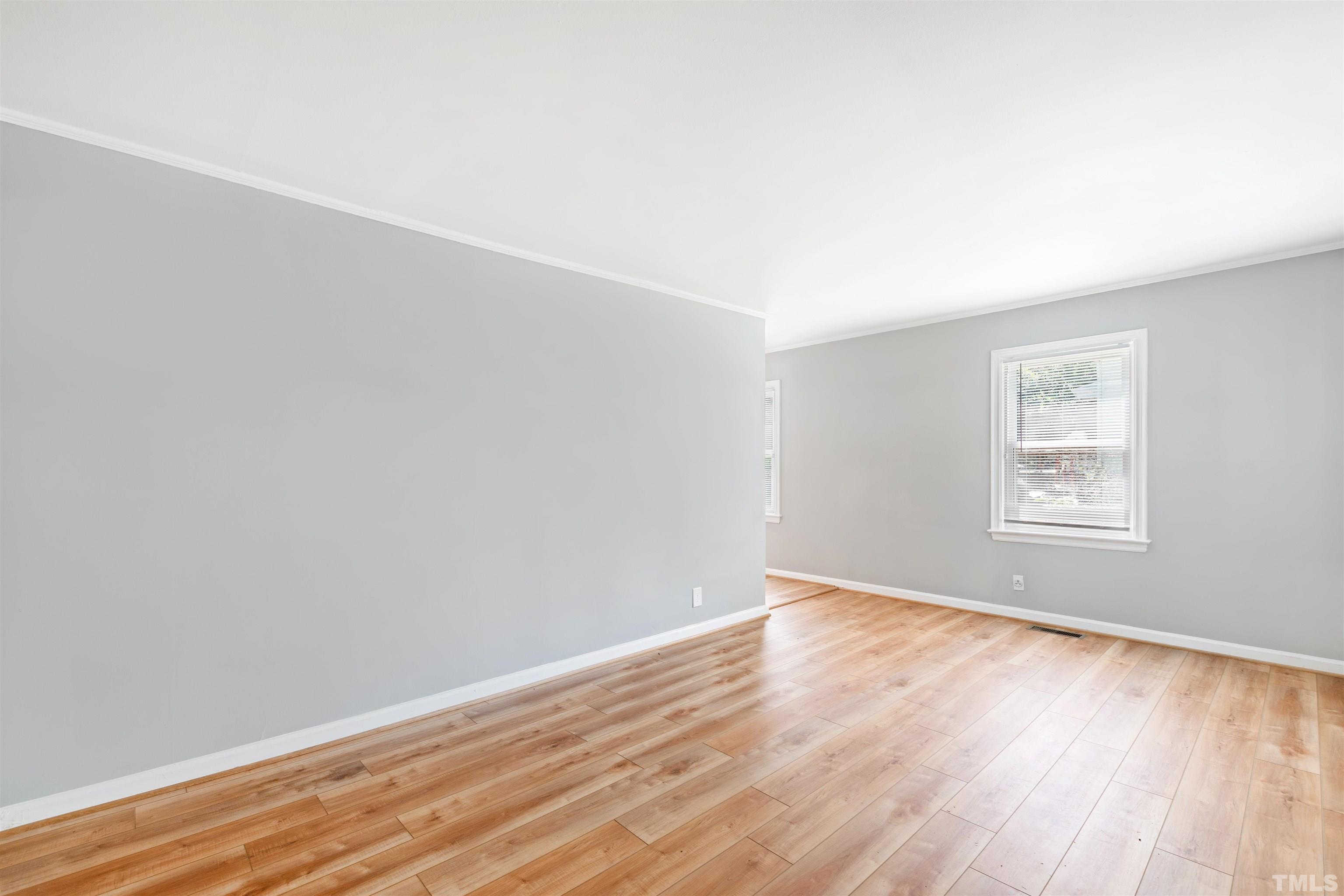 207 Baggett Avenue Raleigh, NC 27604 - Photo 18 of 27 an empty room with wooden floor and windows