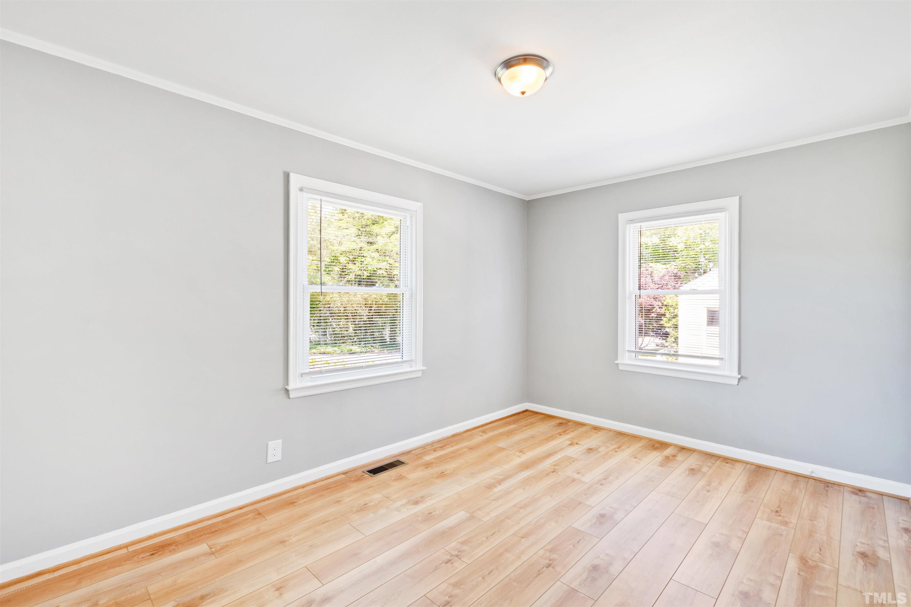 207 Baggett Avenue Raleigh, NC 27604 - Photo 9 of 27 a view of an empty room with wooden floor and a window