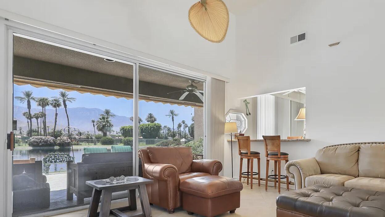141 Lakeshore Drive Rancho Mirage, CA 92270 - Photo 9 of 34 a living room with furniture a lamp and a floor to ceiling window