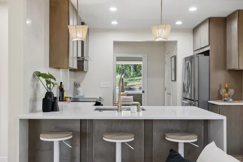 a kitchen with a table chairs sink and refrigerator