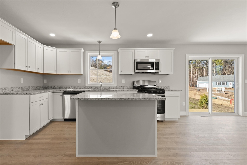 14 R Pne Hl Way, Unit 14 Harvard, MA 01451 - Photo 14 of 41 a kitchen with kitchen island granite countertop a stove a sink a center island and cabinets