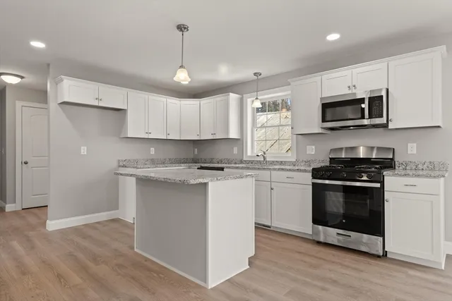 a kitchen with stainless steel appliances granite countertop a sink a stove a microwave and cabinets