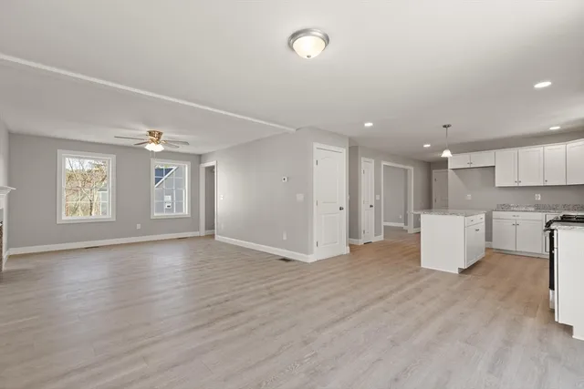 a view of an empty room with window and wooden floor