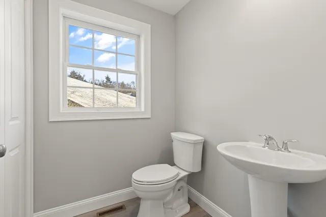 a bathroom with a sink toilet and a window