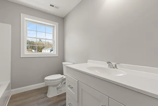 a bathroom with a sink toilet and window