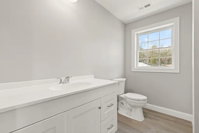 a bathroom with a sink a toilet and a window