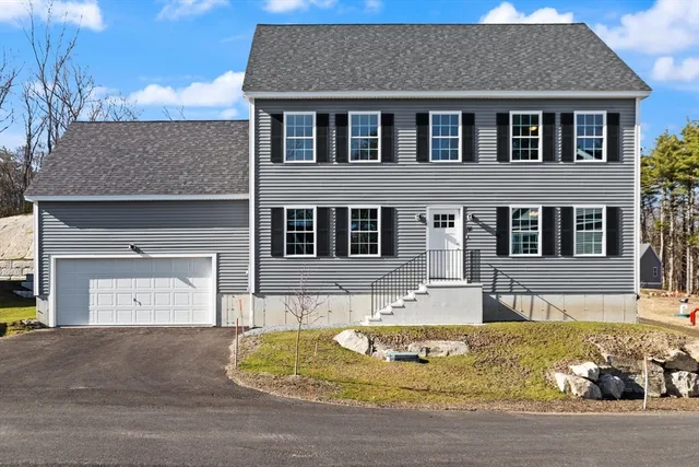 a front view of a house with a yard garage and outdoor seating