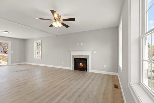 a view of an empty room with window and wooden floor