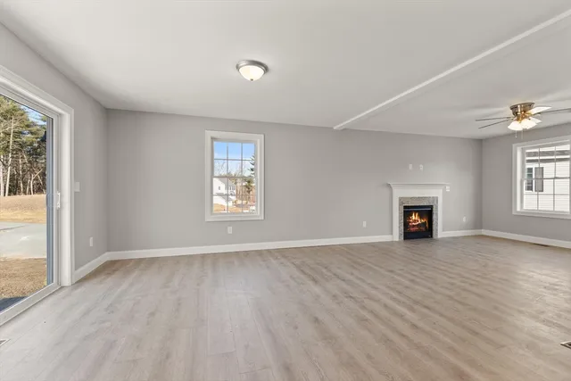 an empty room with windows and fireplace