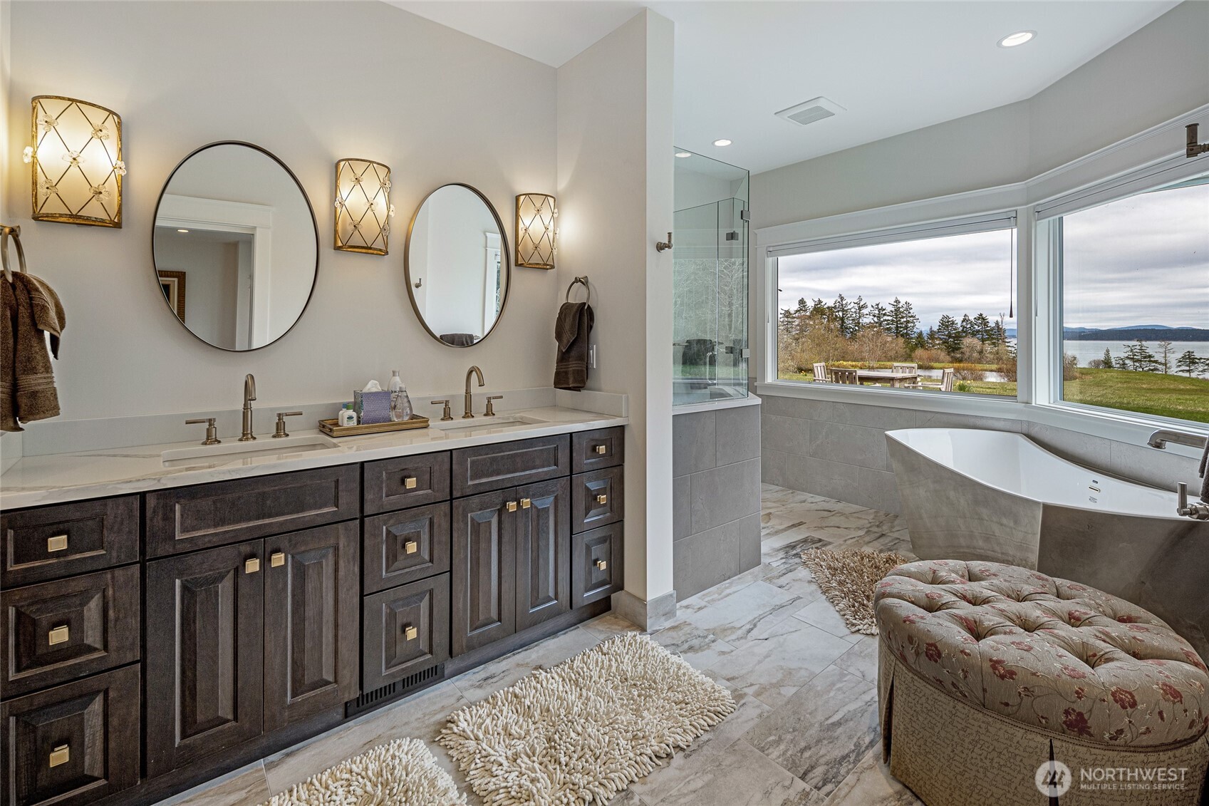 735 Rosler Road San Juan Island, WA 98250 - Photo 23 of 40 a spacious bathroom with a granite countertop tub a double vanity sink and a large mirror