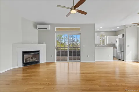 a view of a livingroom with wooden floor a fireplace and window