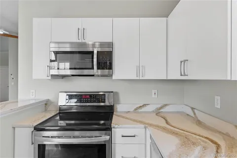 a kitchen with appliances a sink and cabinets