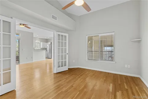 an empty room with wooden floor and windows
