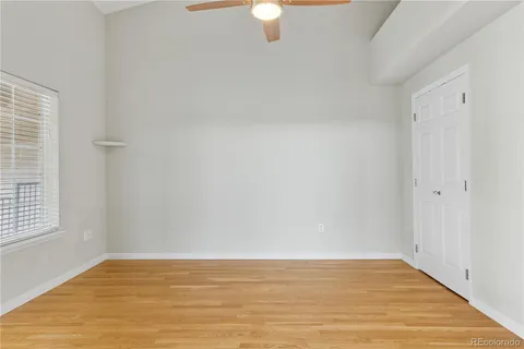 a view of an empty room with window and wooden floor