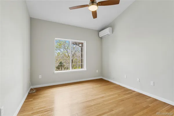 an empty room with a window and a ceiling fan