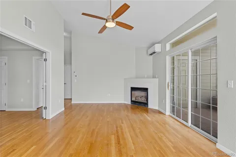 a view of empty room with wooden floor and fireplace