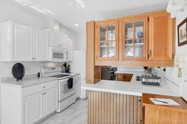 a kitchen with stainless steel appliances granite countertop a stove a sink and white cabinets