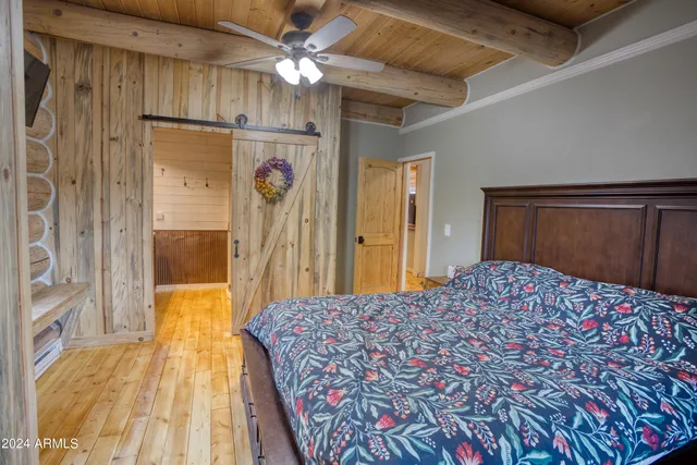 a bedroom with a bed and a flat tv screen on dresser