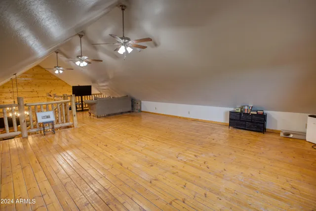 a living room with wooden floor furniture and a ceiling fan