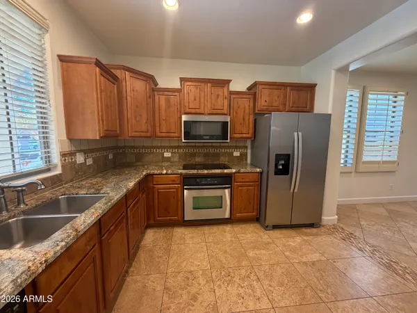 a kitchen with stainless steel appliances granite countertop a refrigerator stove and sink