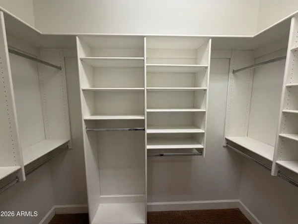 a view of walk in closet with empty racks