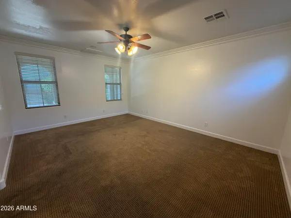 an empty room with windows and fan
