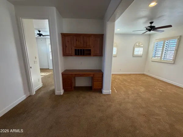 an empty room with windows and cabinet