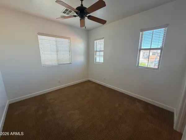 an empty room with a window and a fan
