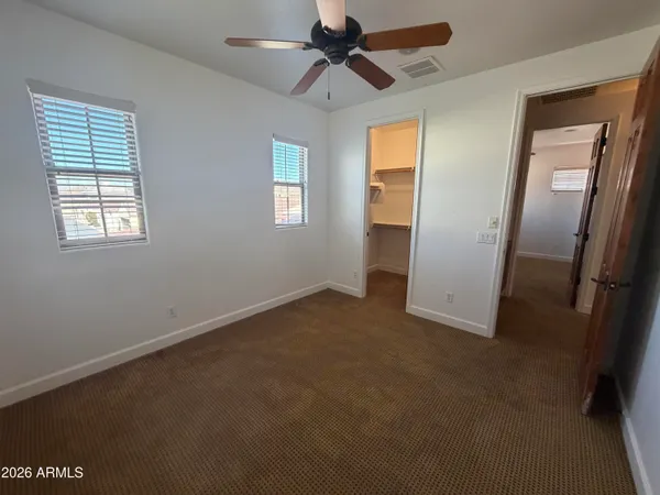 an empty room with windows and a ceiling fan